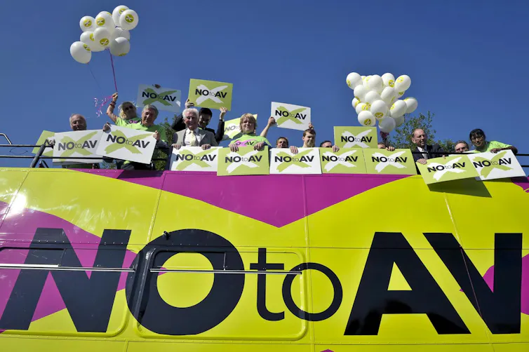 Campaigners for 'No to AV' wave campaign material from a bus in 2011.