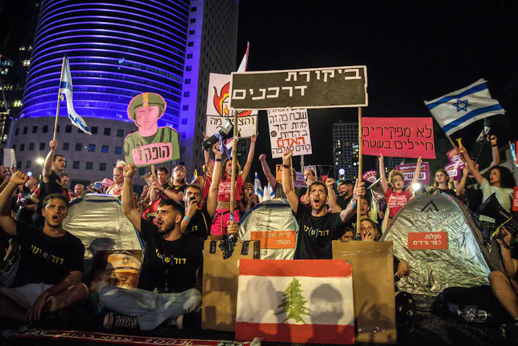 An Israeli protest with banners reading 'passport control'