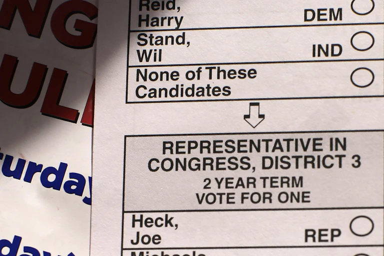 A ballot shows the option 'None of these candidates' below the list of candidates.
