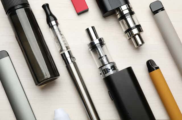 A variety of e-cigarette products lying flat on a white surface.