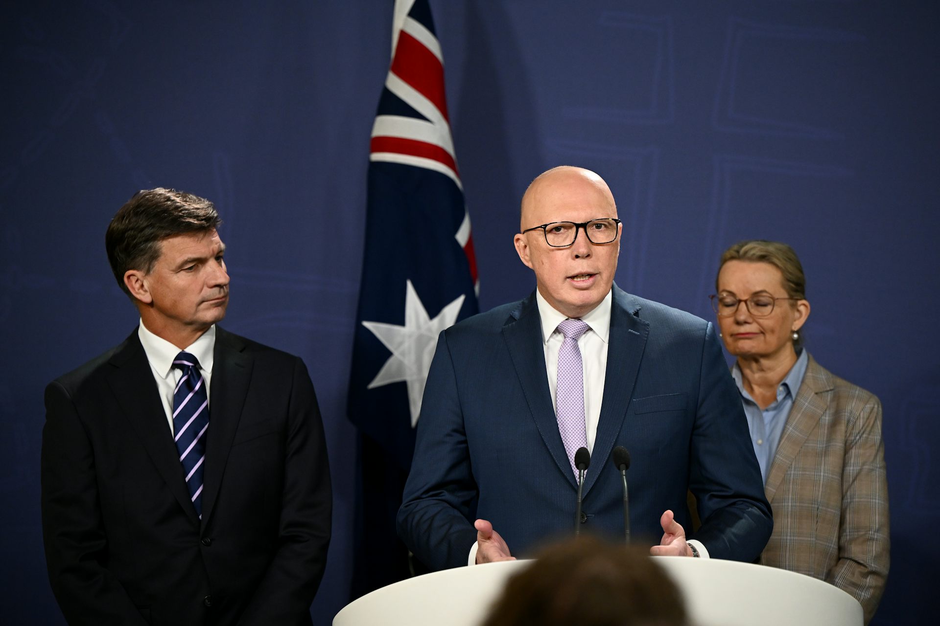 Two men and a woman on podium