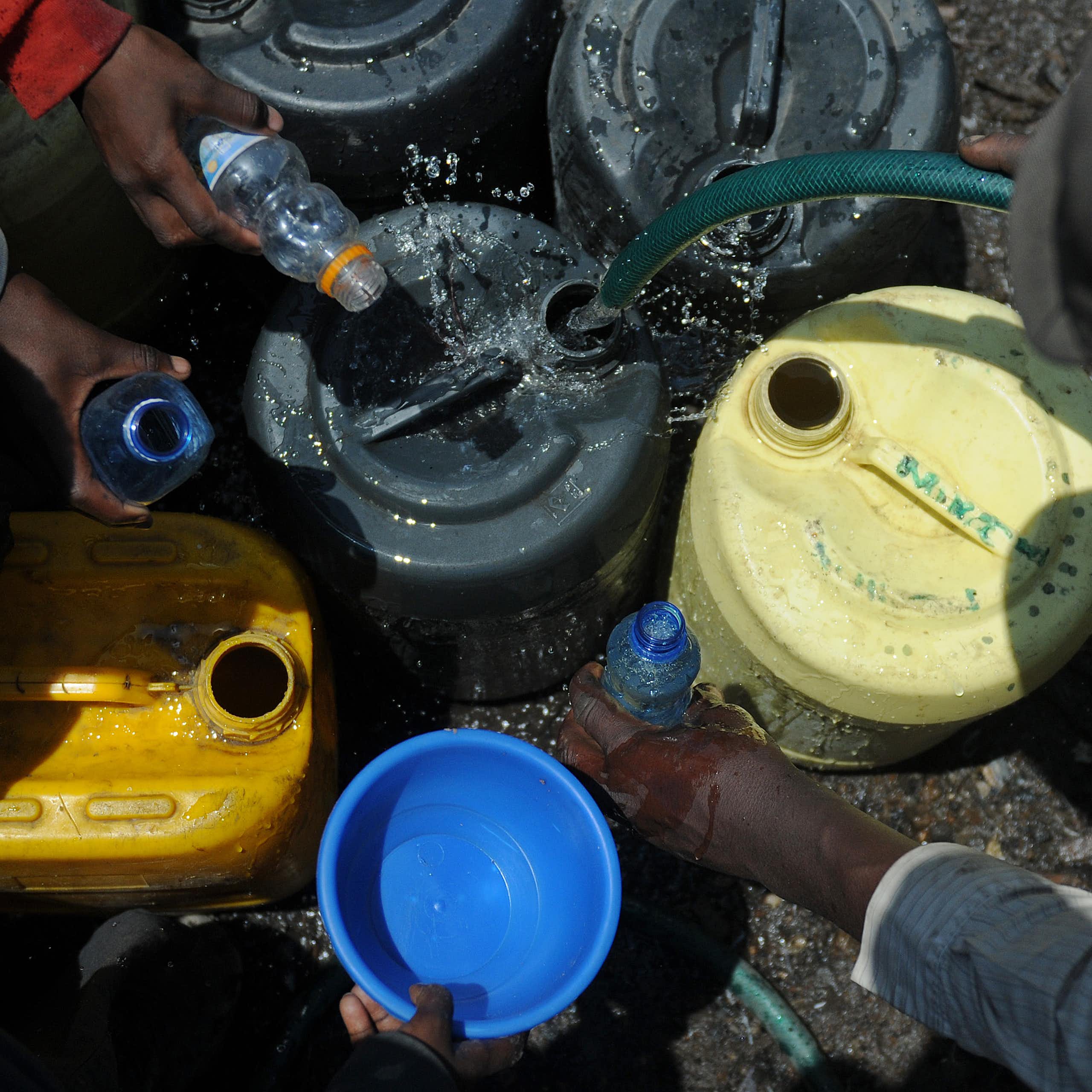 Residents fetch water in small bottles 