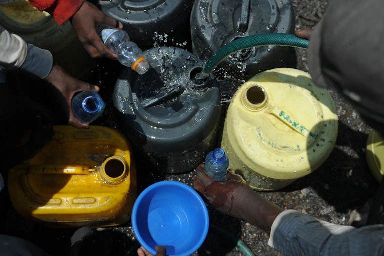 Residents fetch water in small bottles