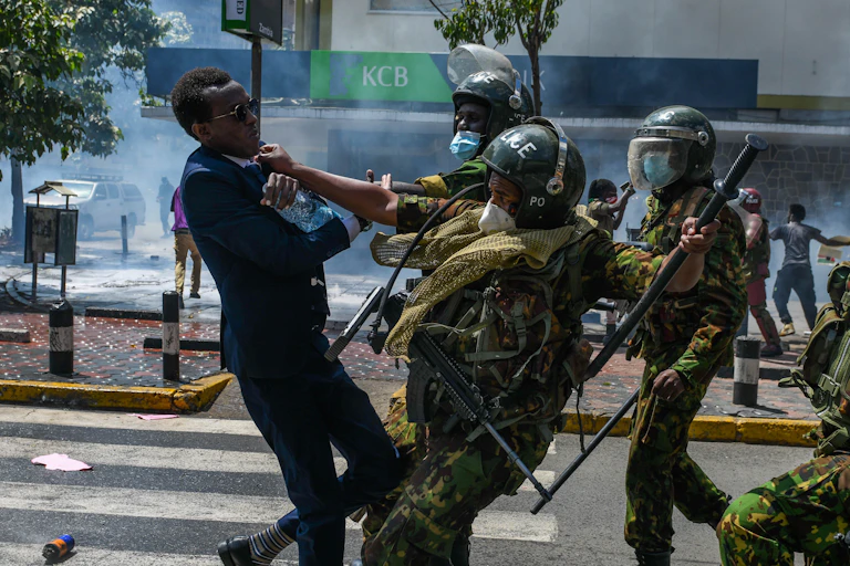 A group of police officers push a man back