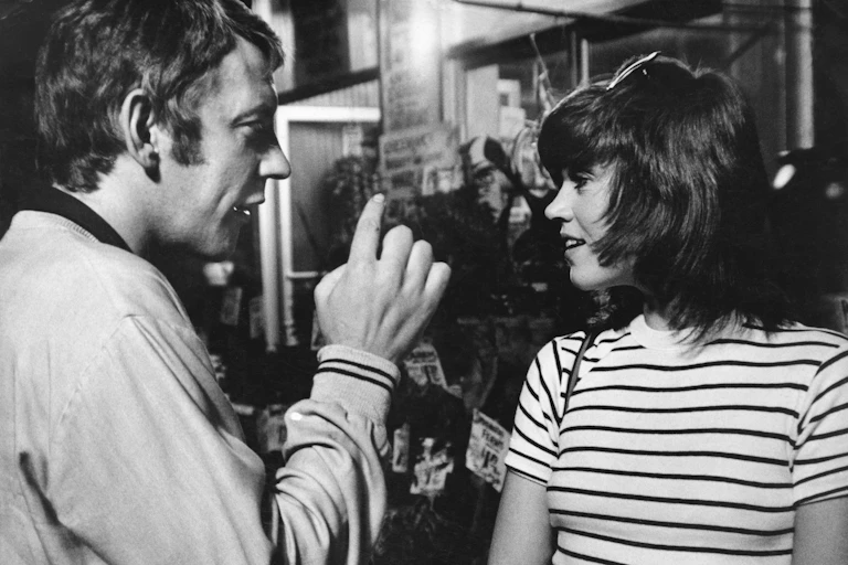 A black and white photo of a young couple talking.