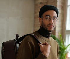 A Black young male student with backpack.