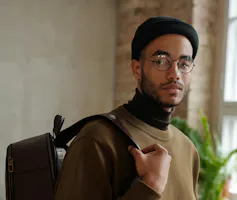 A Black young male student with backpack.