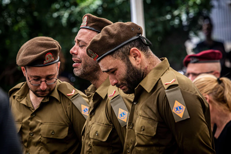 Members of the Israel Defense Forces weep at the funeral of a comrade.