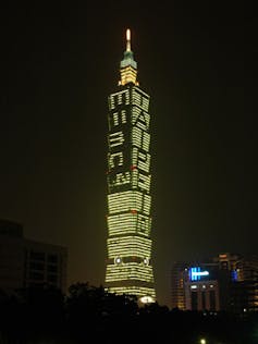 Sur la facade de la tour, des fenêtres éclairées écrivent à la verticale E = mc²
