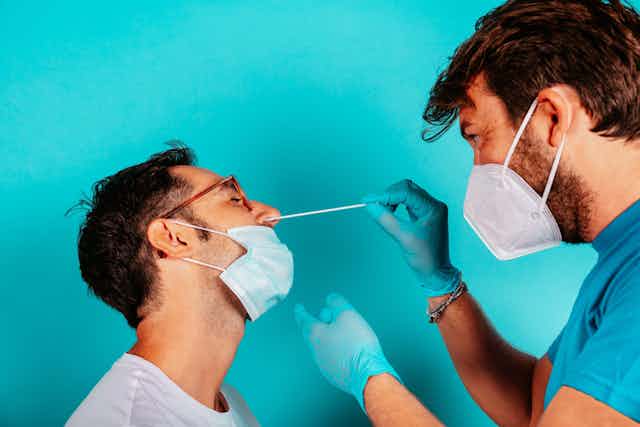 write group by Man being swabbed by medic for COVID