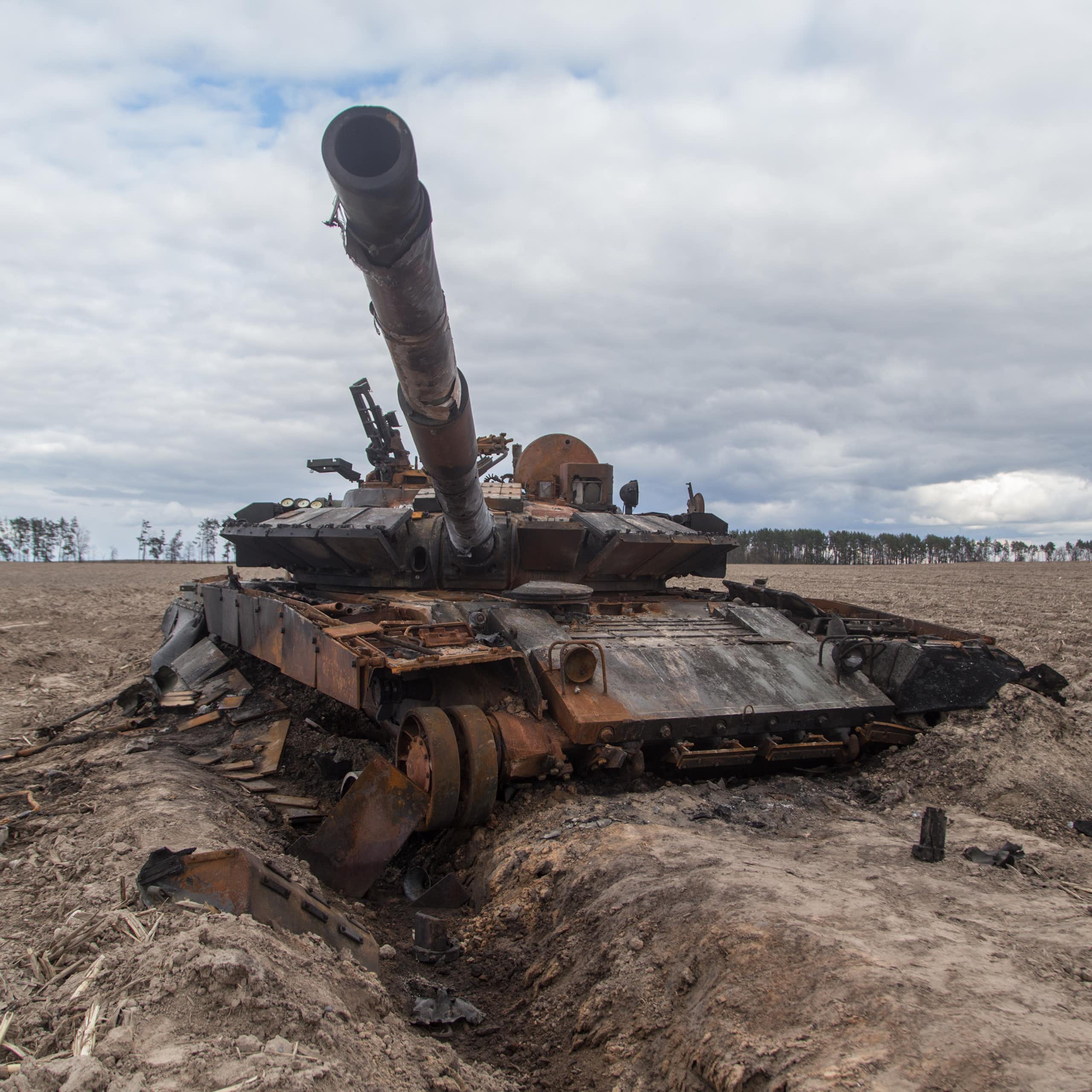 A destroyed tank sat in the middle of a field.