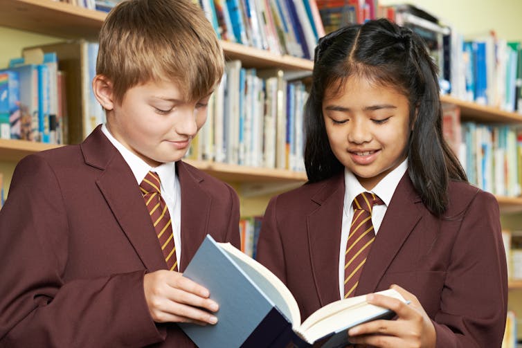 Pupils wearing uniform in library.