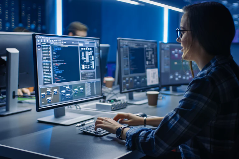 A woman coding, in front of a computer