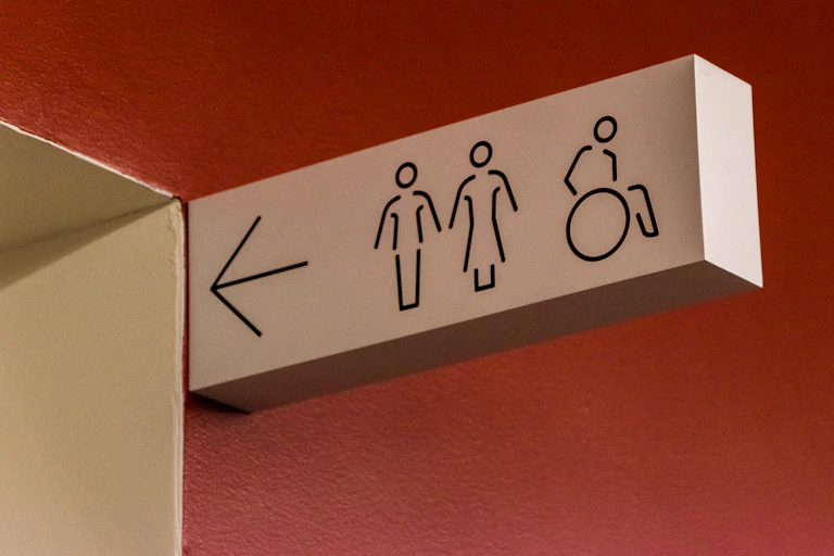 A sign pointing towards men's, women's and disabled restrooms