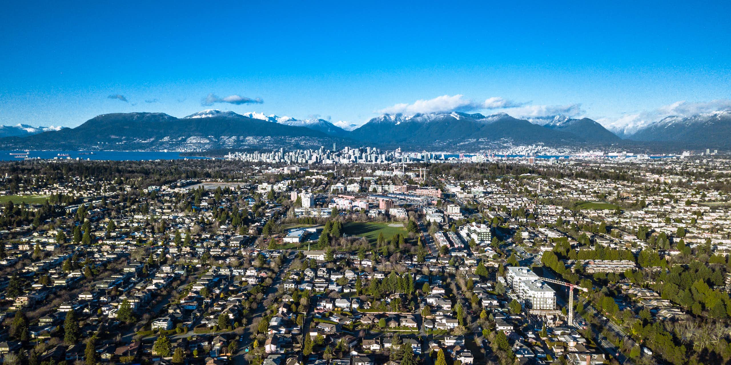 An aerial view of an urban area with mountains in the background.