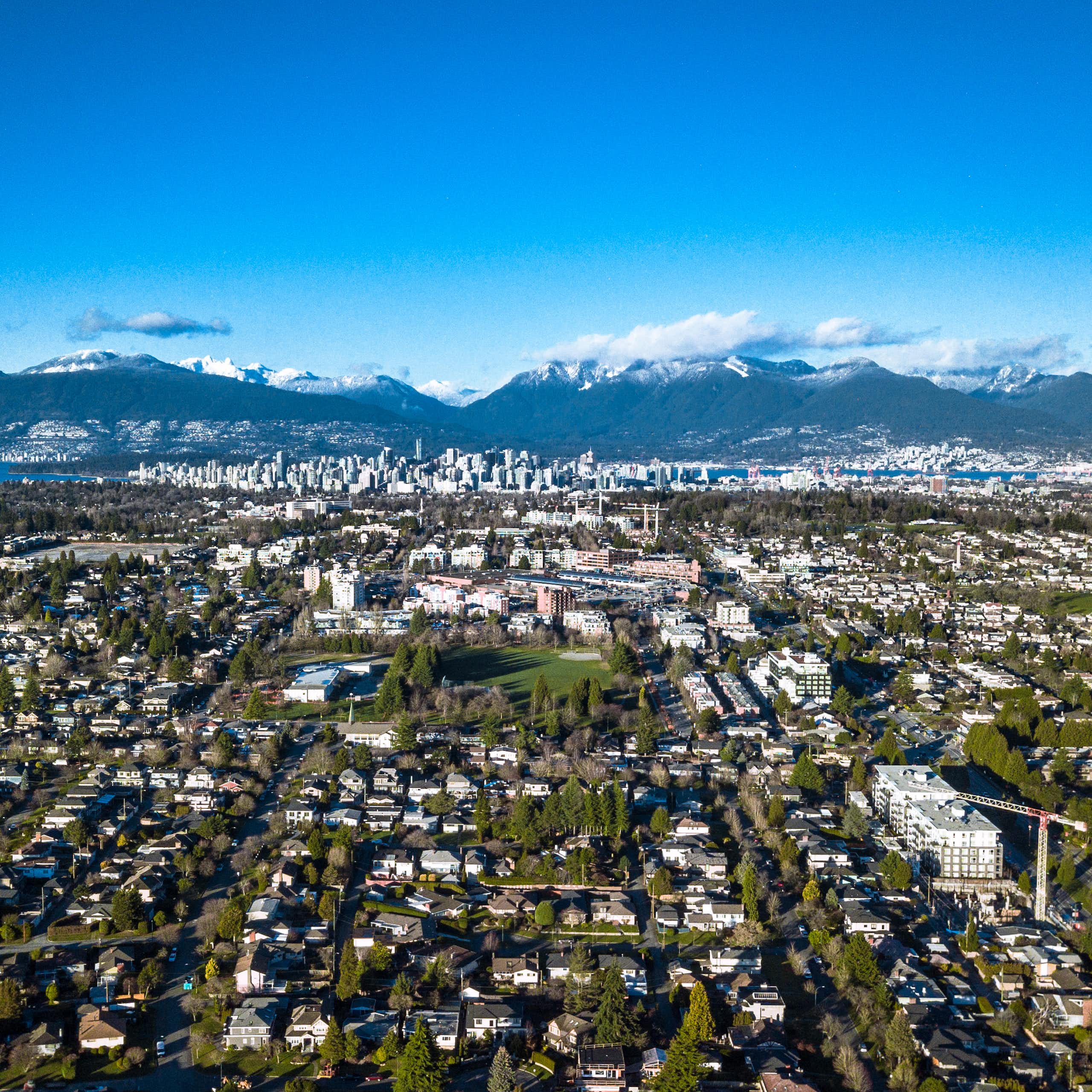 An aerial view of an urban area with mountains in the background.