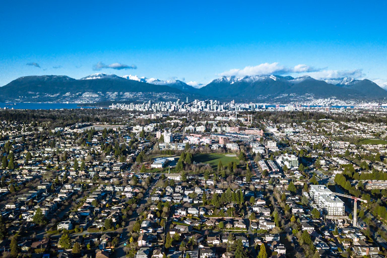An aerial view of an urban area with mountains in the background.