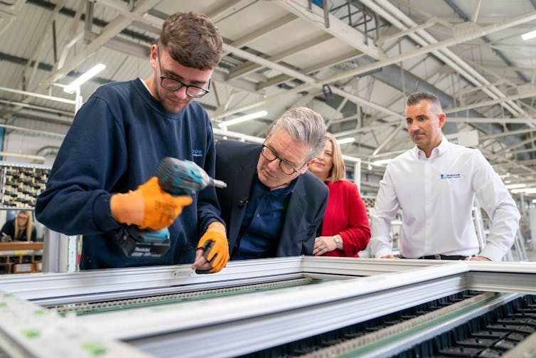 Keir Starmer watches a factory worker make a window in Bathgate, West Lothian.