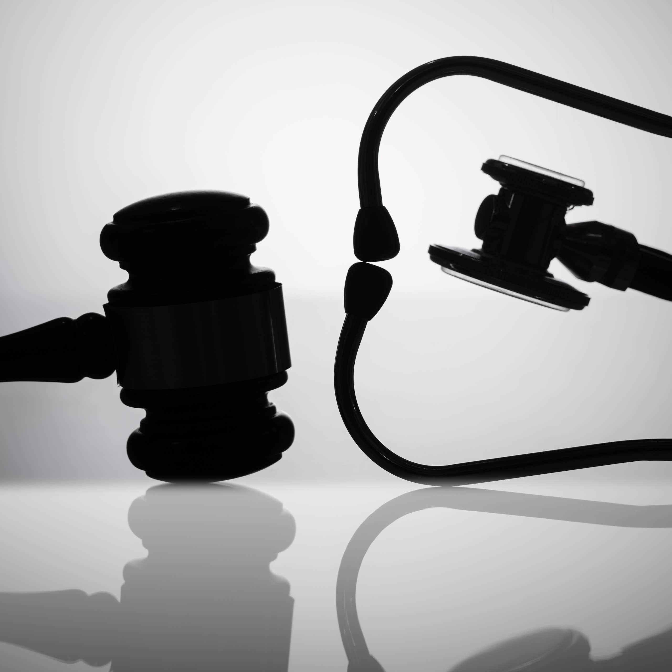 Silhouettes of a judge's gavel and a stethoscope.