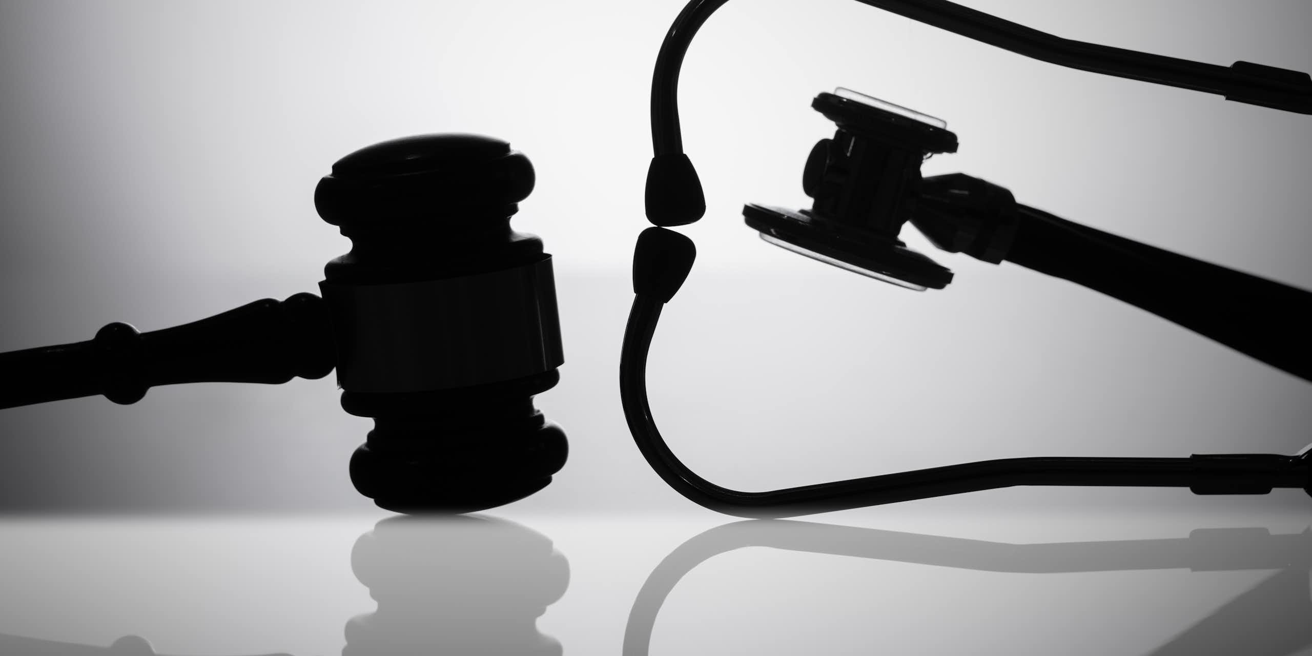 Silhouettes of a judge's gavel and a stethoscope.