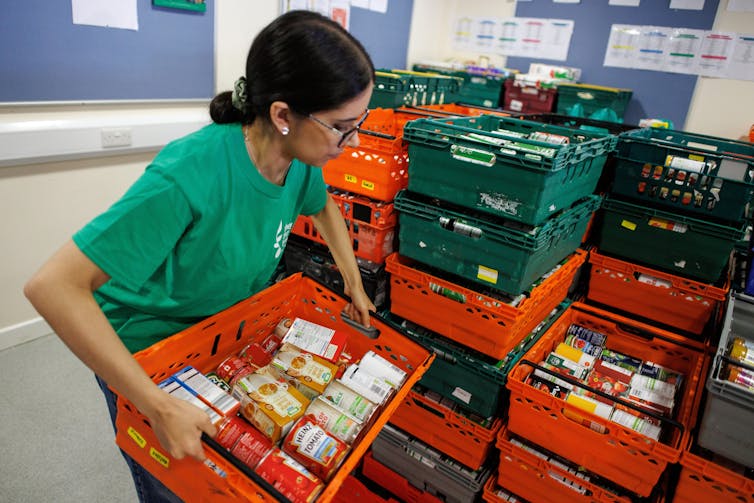 A woman sorts food at a foodbank in London.