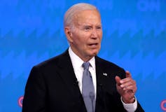 A white man with gray hair answers a question during a presidential debate.