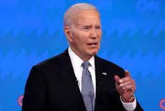 A white man with gray hair answers a question during a presidential debate.