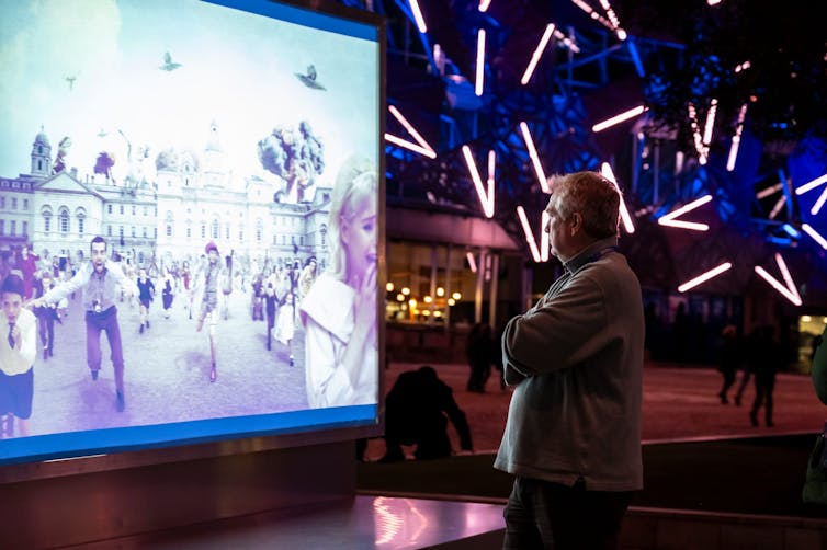 A man watches a screen.