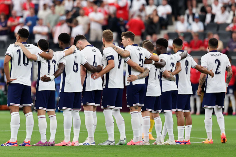 The England team seen from behind lined up with arms linked before a match at EEuro 2024.