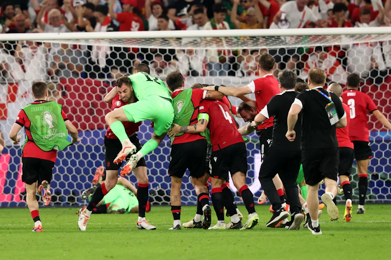 The Georgian football team celebrating together in front of their fans.