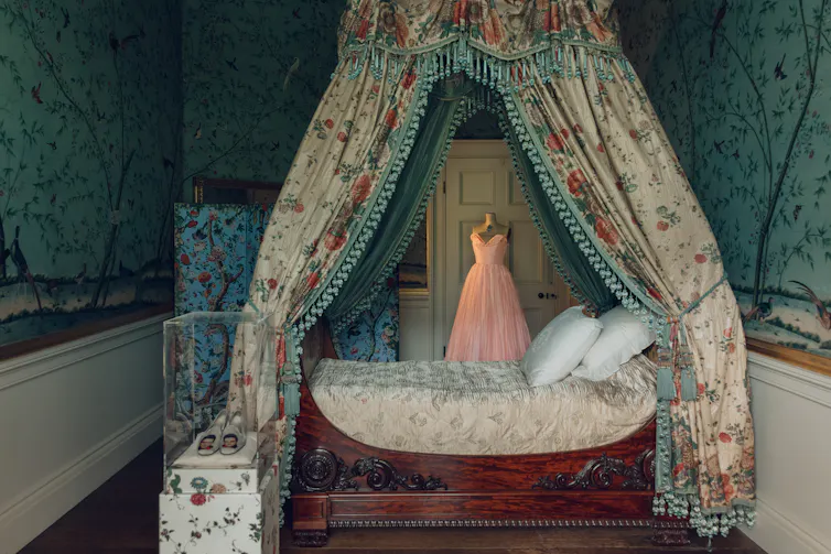 A beautiful bedroom in an English baroque house complete with canopied bed and floral wallpaper.