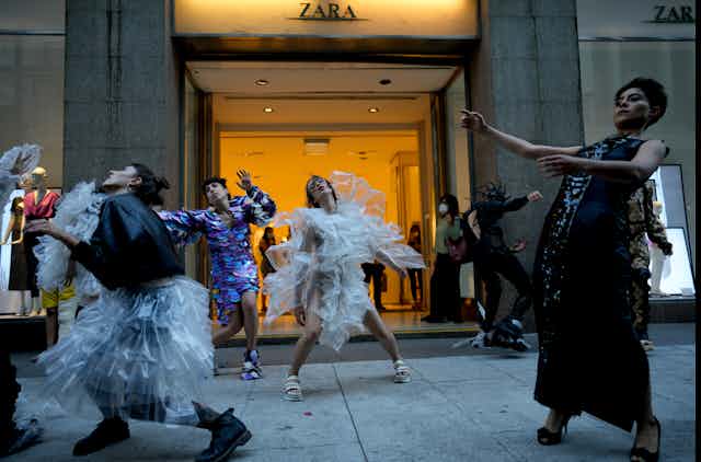 Des personnes dansent devant la devanture d'un magasin.