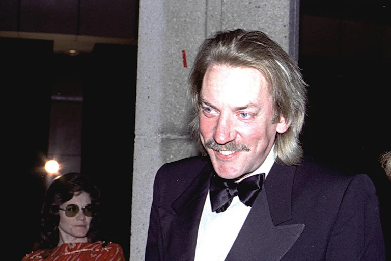 A man in tuxedo smiling.