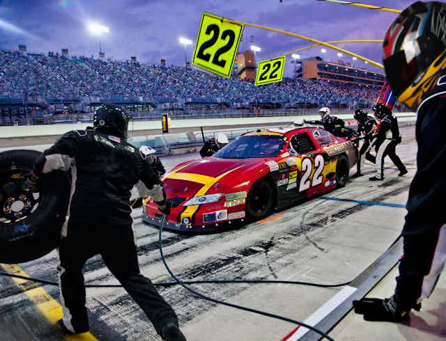 how to solve a physics problem A pit crew works on a car at a racetrack.