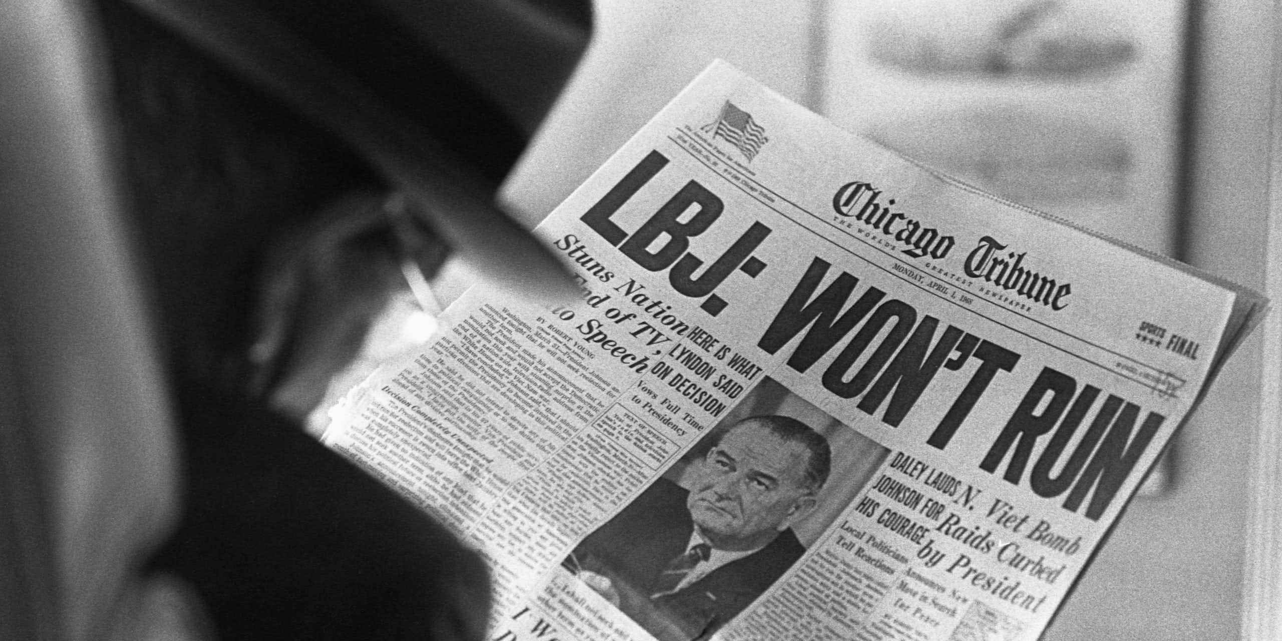 A man is reading a newspaper headline that says LBJ won't run in very large letters.