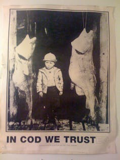 A flyer that says 'IN COD WE TRUST' below a black and white photo of a child standing between two fish