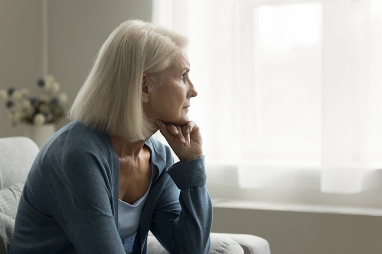 An older woman staring out of the window,