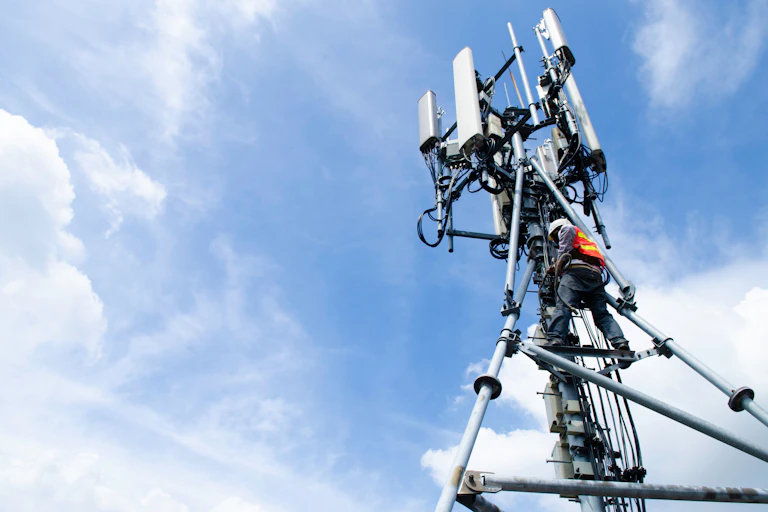 Technicien sur une antenne telecom.
