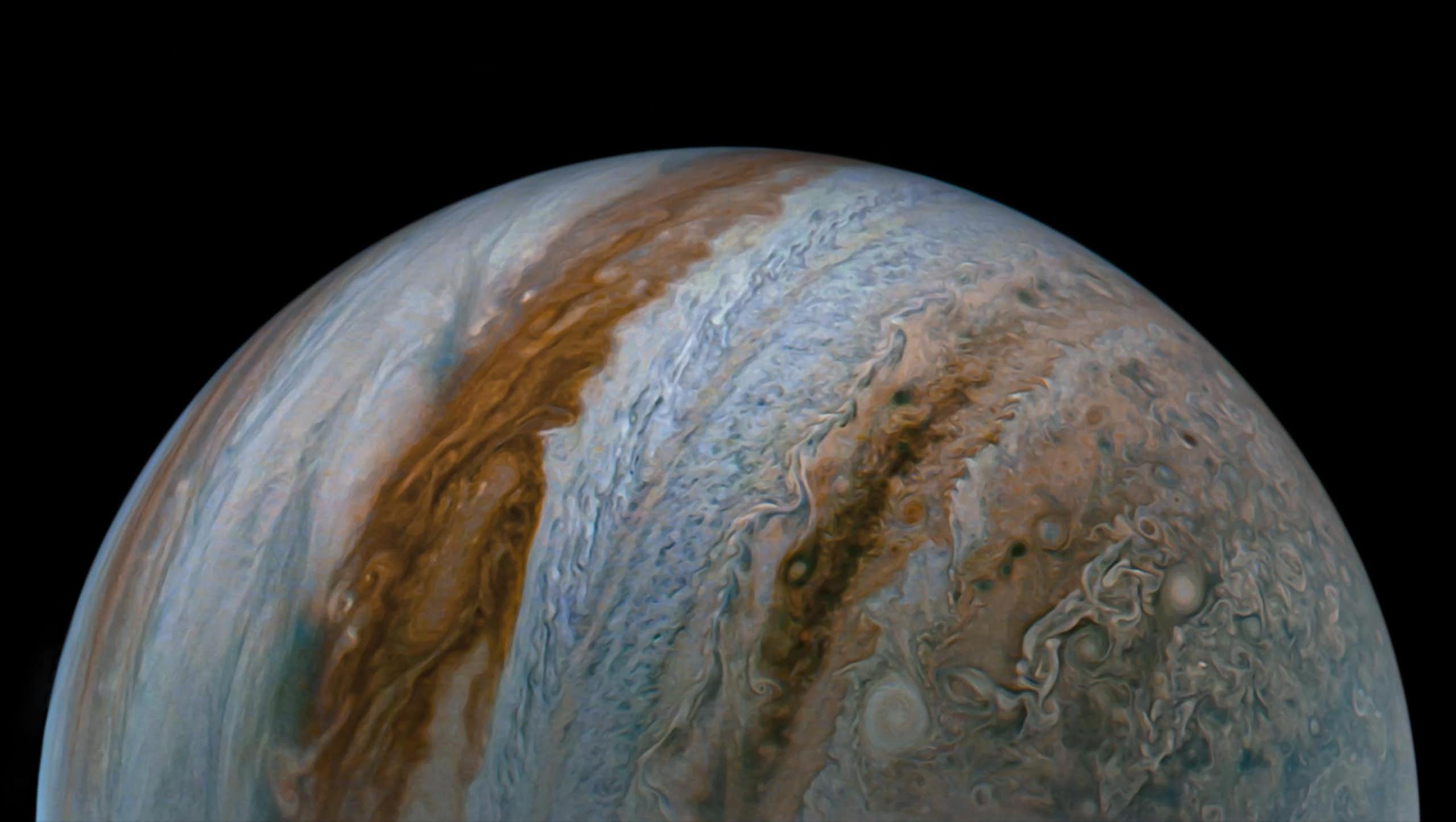 An image of Jupiter shows cloud tops and colorful blue and brown belts covering the planet.