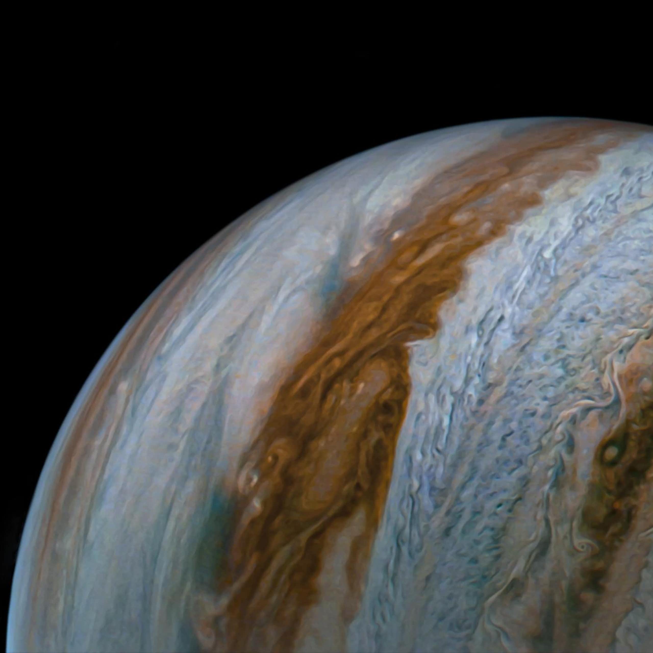 An image of Jupiter shows cloud tops and colorful blue and brown belts covering the planet.