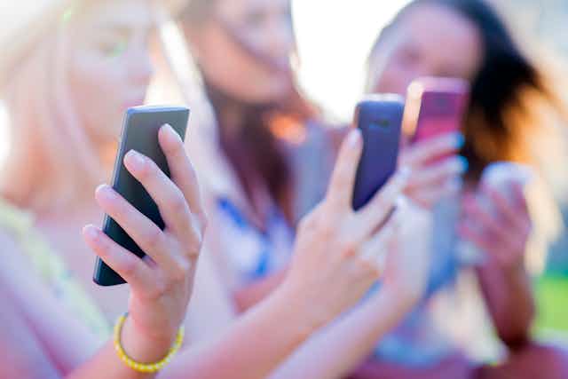 teenagers holding smartphones