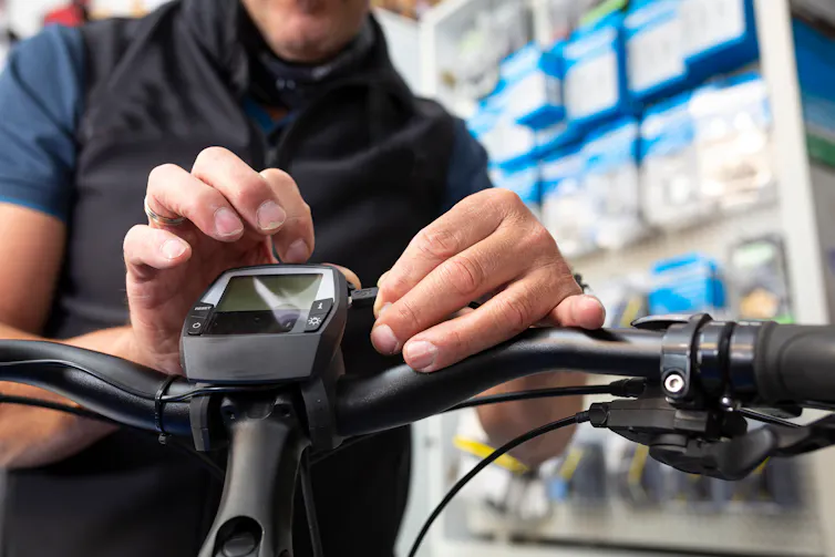 man tinkers with e-bike
