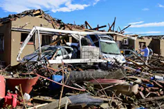 A destroyed house and car after being hit by a tornado