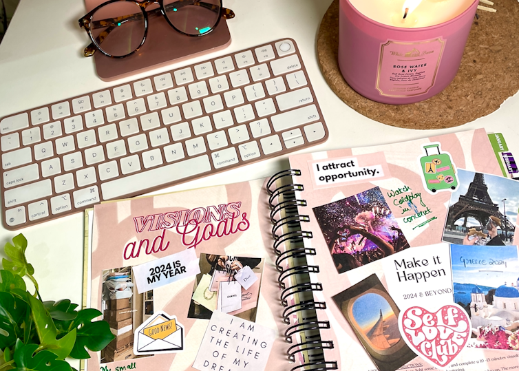 Desk with notebook of goals, candle, plant
