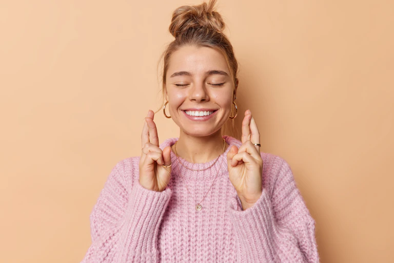 Woman with fingers crossed wishing