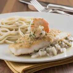 A piece of breaded white fish on a plate with pasta.