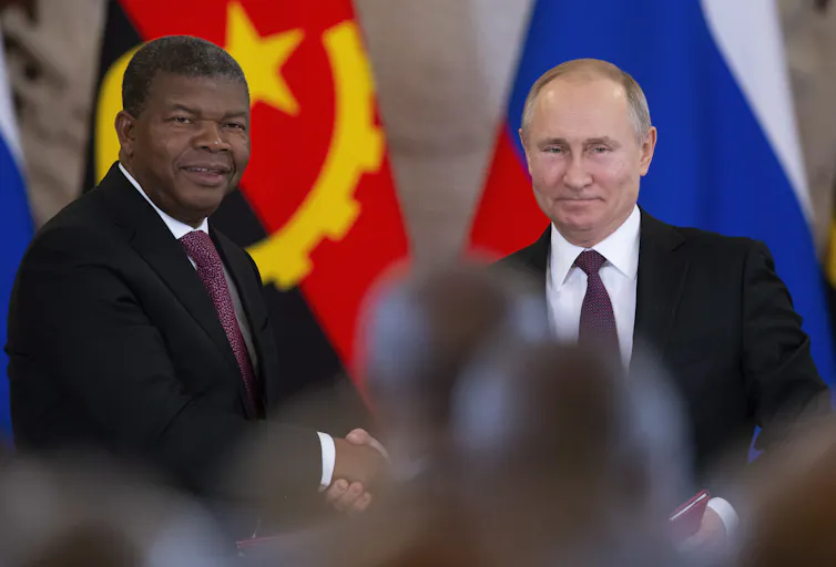 two men in suits shaking hands.