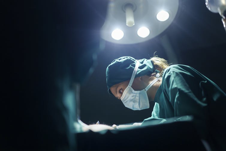 Surgeon operating under theatre lights