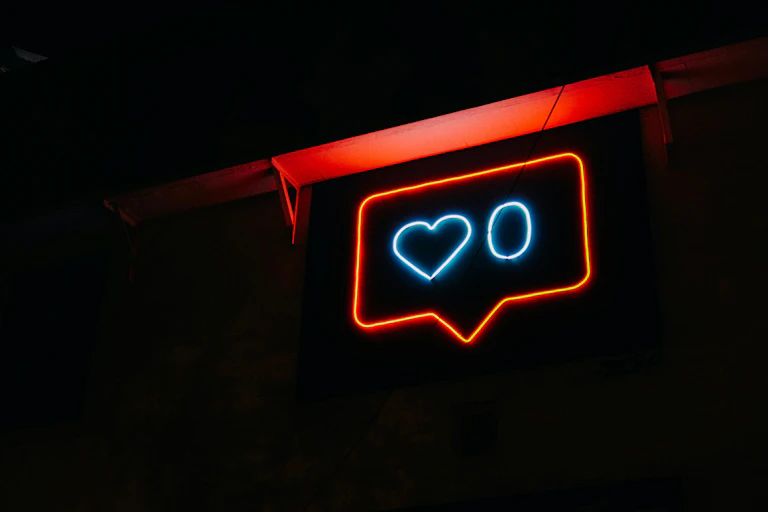 A neon sign of the like symbol, showing zero likes.