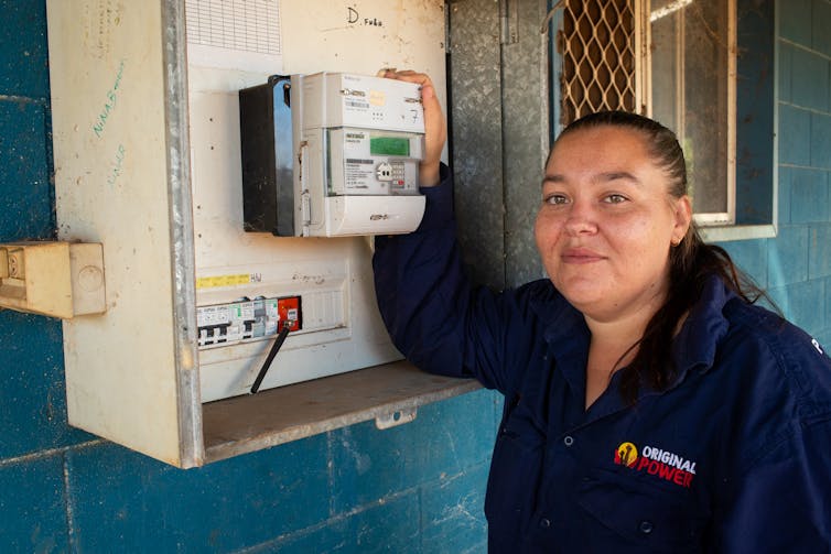 A worker at Original Power with her meter box at her home in Marlinja, Northern Territory